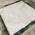 Polished Afghan White Onyx slab in bright white background with soft grey and honey toned natural veins